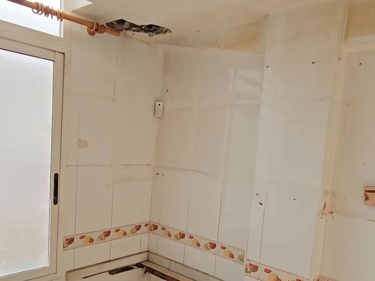 Cocina antigua con alicatado de cenefa y tomas de agua vistas, antes de la reforma
