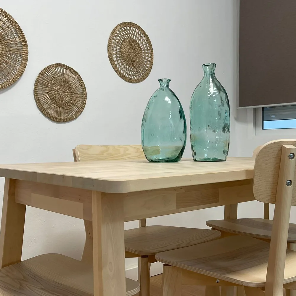 Zona de comedor con mesa de madera y decoración en fibras naturales