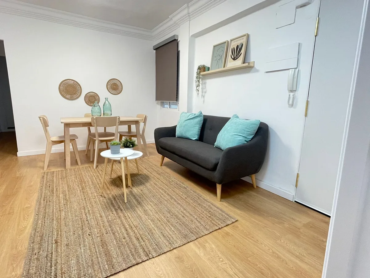 Salón comedor reformado en Catarroja con suelo de madera y mobiliario claro